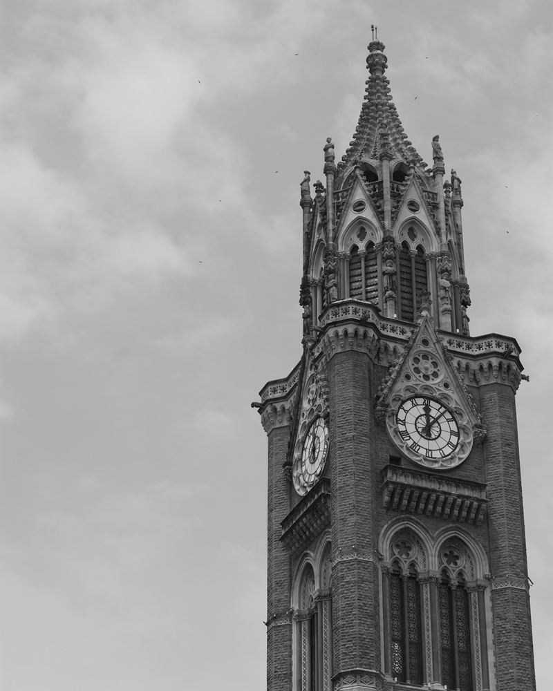Rajabai Clock Tower in Mumbai's Fort district against an overcast sky