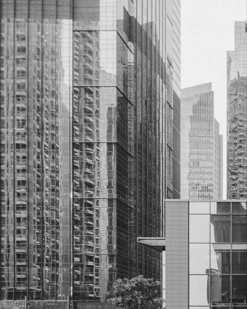 Reflective glass towers of Jakarta's Sudirman Central Business District above a terraced stone podium