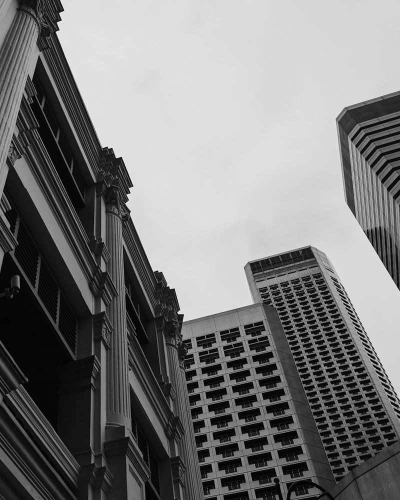 Colonial pilasters and modern towers in Singapore's civic district, seen from below