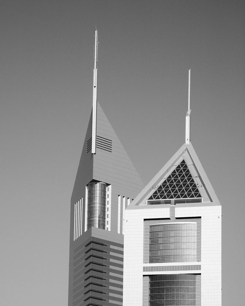 The crowns of the Emirates Towers against a clear sky in Dubai