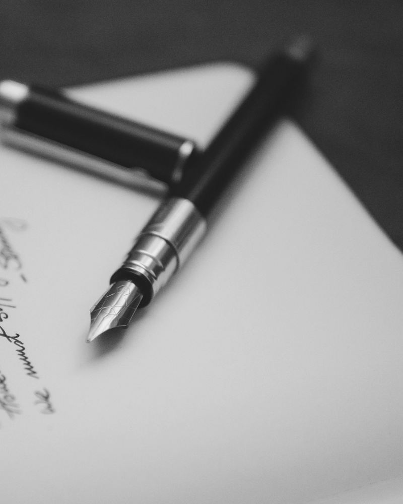 A fountain pen resting on a handwritten letter